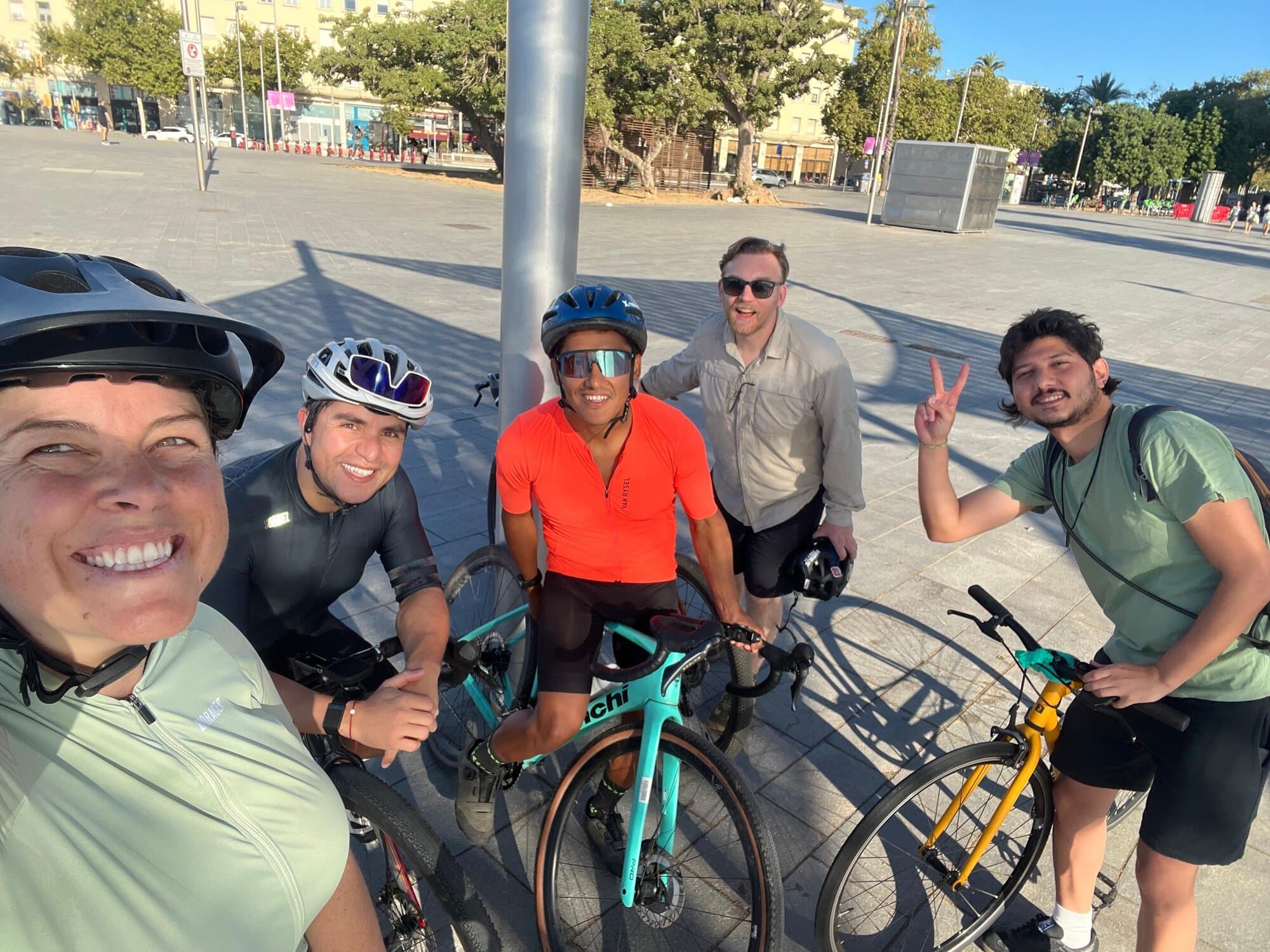 Five Keep Calm cyclists smiling with their bikes in a Barcelona plaza after a group ride, Keep Calm Community Barcelona