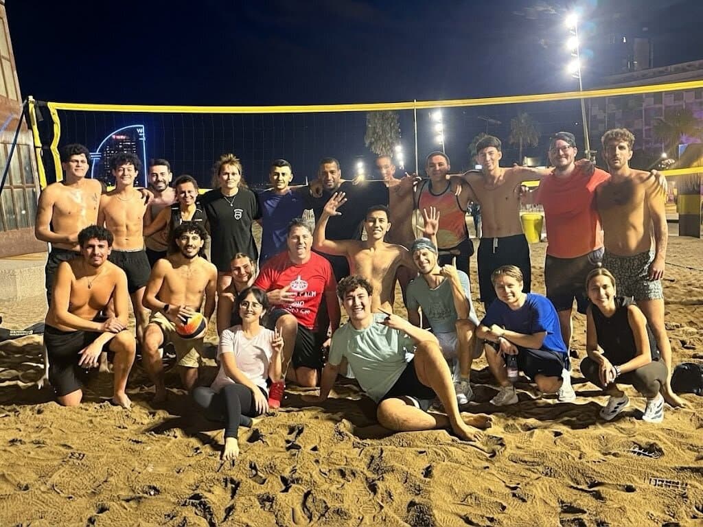 Keep Calm Community group photo under the floodlights after a late night beach volleyball session in Barcelona